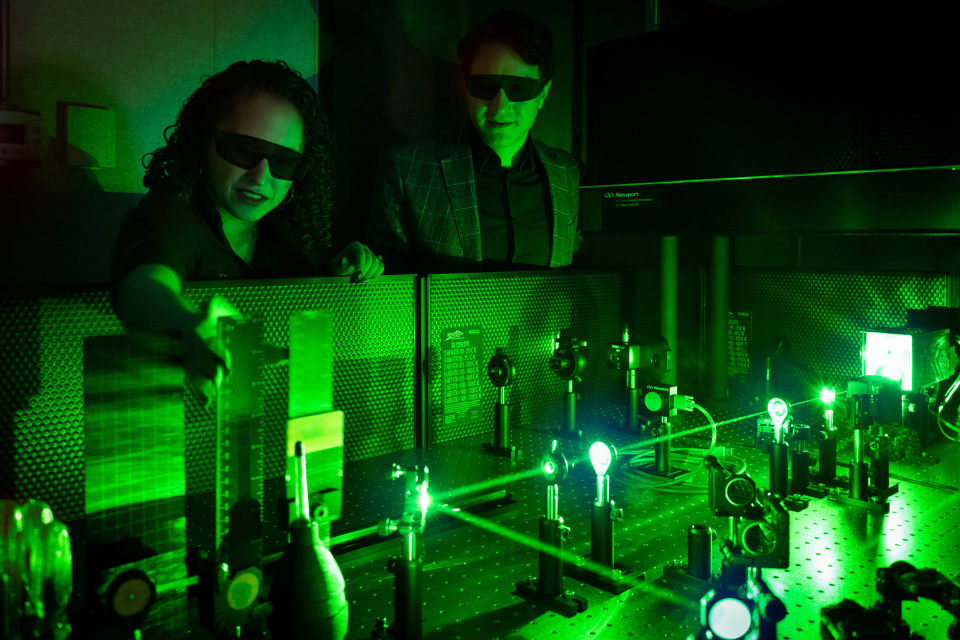 Two individuals analyzing light reflection